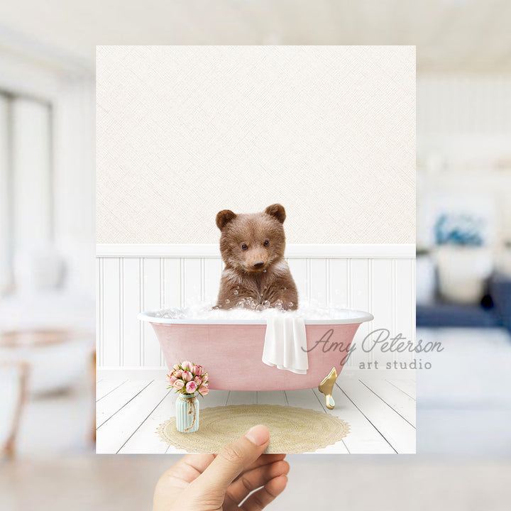 a person holding a card with a picture of a teddy bear in a bathtub