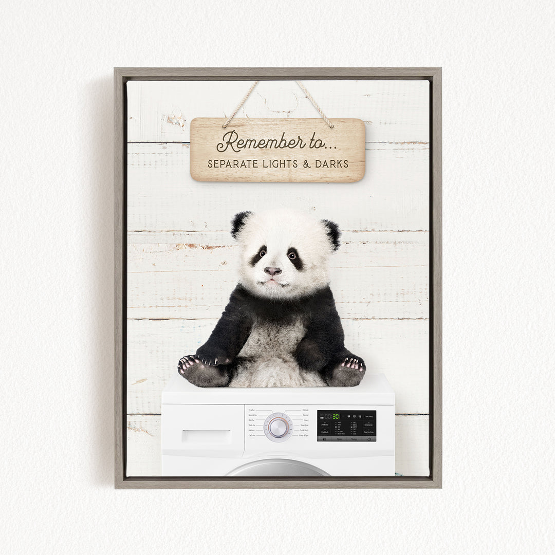 A panda bear sitting on top of a washing machine, with a wooden sign above that reads "Remember to separate lights & darks".