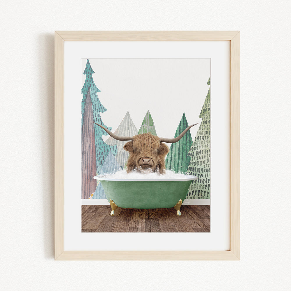A framed print depicting a Highland cow with long horns sitting in a green bathtub, surrounded by a forest scene.