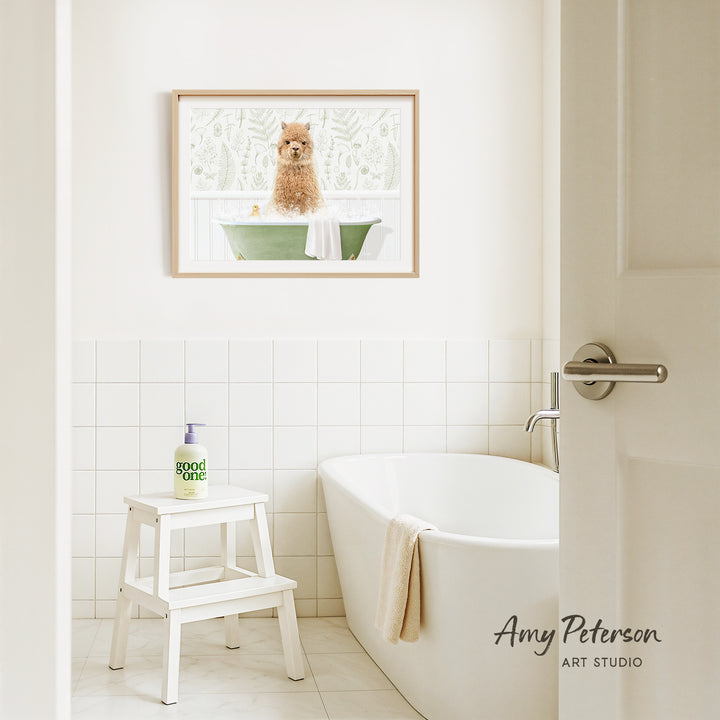 A framed image of a dog sitting in a bathtub is hanging on a white tiled wall above a white bathtub in a bathroom.