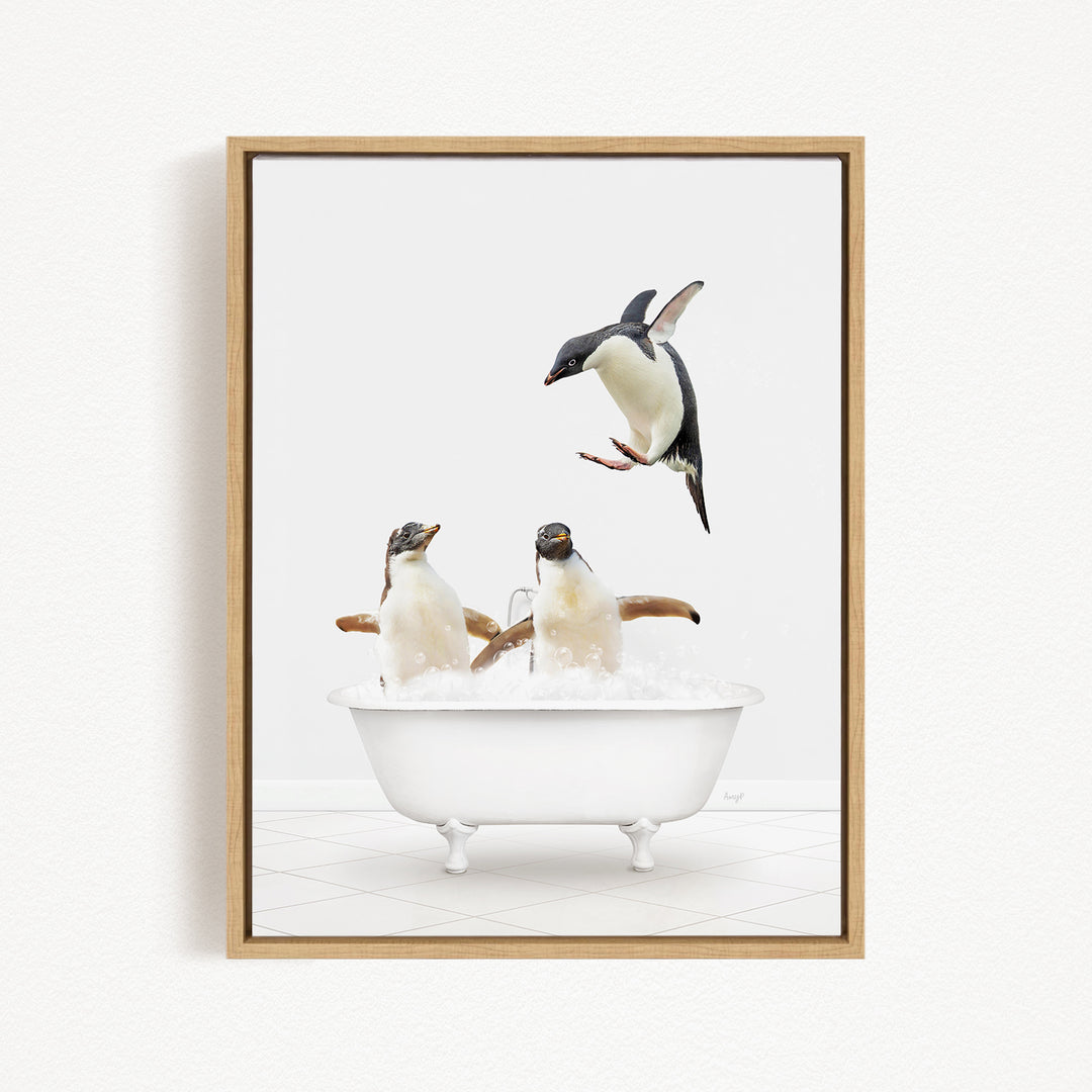 A framed image depicting two penguins sitting in a bathtub, with one penguin jumping out of the tub.