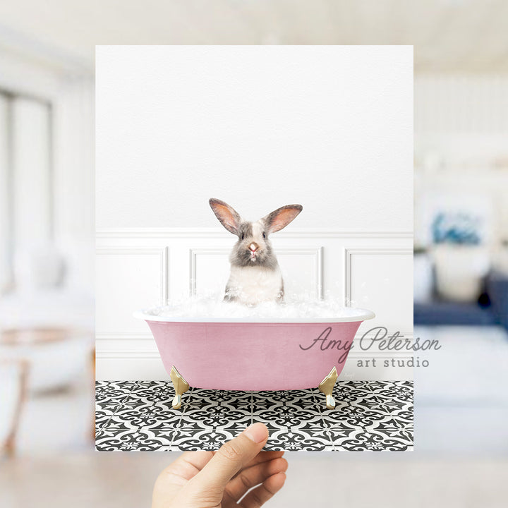 a person holding up a card with a rabbit in a bathtub