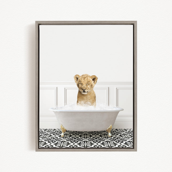 A young lion cub sitting in a white bathtub filled with water, with a black and white patterned floor beneath it.