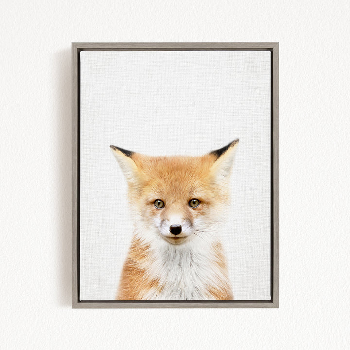 A framed photograph of a young fox with a friendly expression, looking directly at the camera.