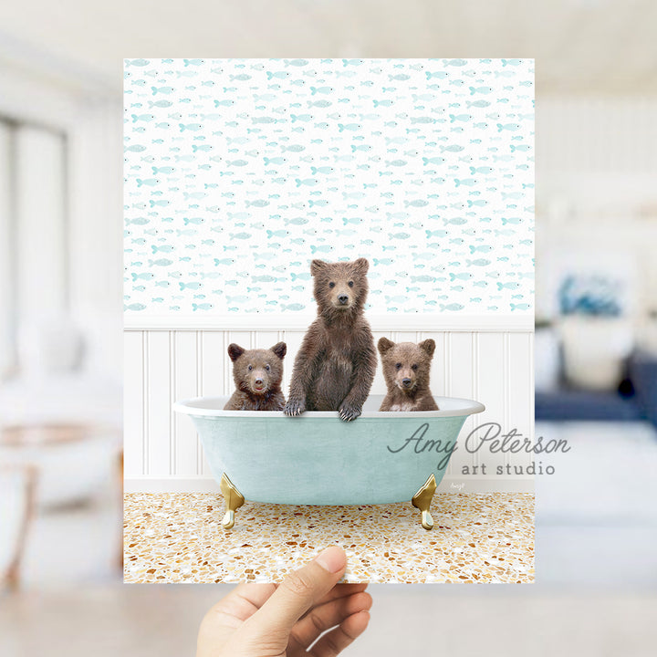 a person holding up a card with three bears in a bathtub