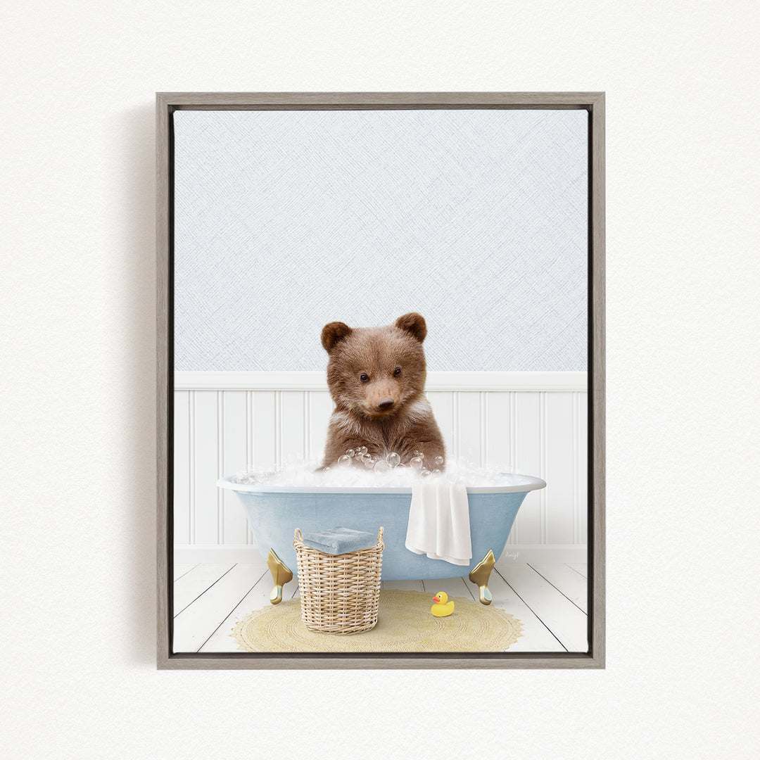 A brown bear sitting in a blue bathtub filled with water, surrounded by a yellow rubber duck and a white basket.