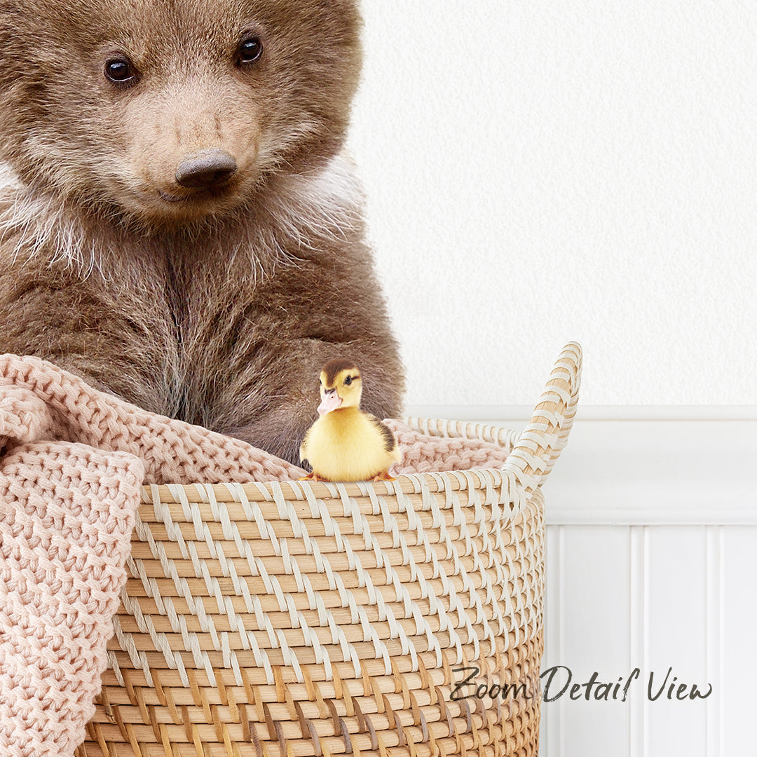 A brown bear sits in a woven basket, with a small yellow duck perched on the edge of the basket.