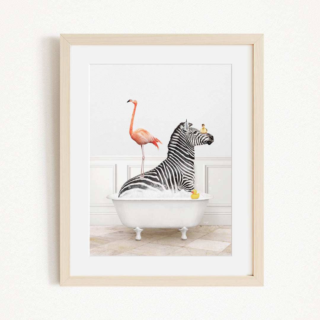 A framed image depicting a zebra sitting in a bathtub, with a flamingo standing on its back and a yellow rubber duck floating in the water.