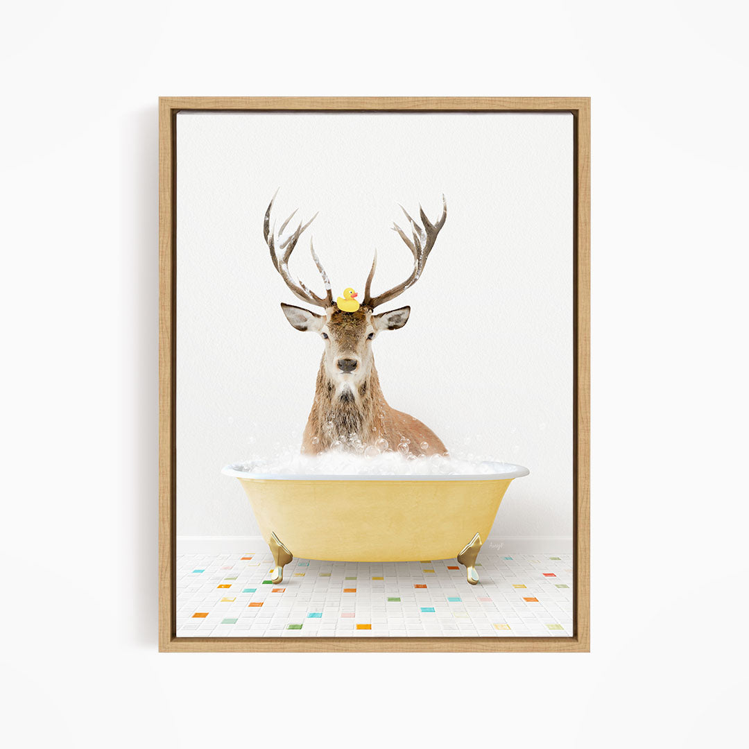 A deer with antlers is sitting in a yellow bathtub filled with bubbles, with a rubber duck perched on its head.