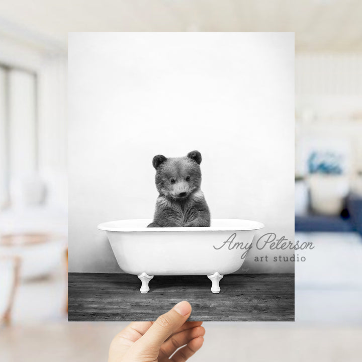 a black and white photo of a bear in a bathtub