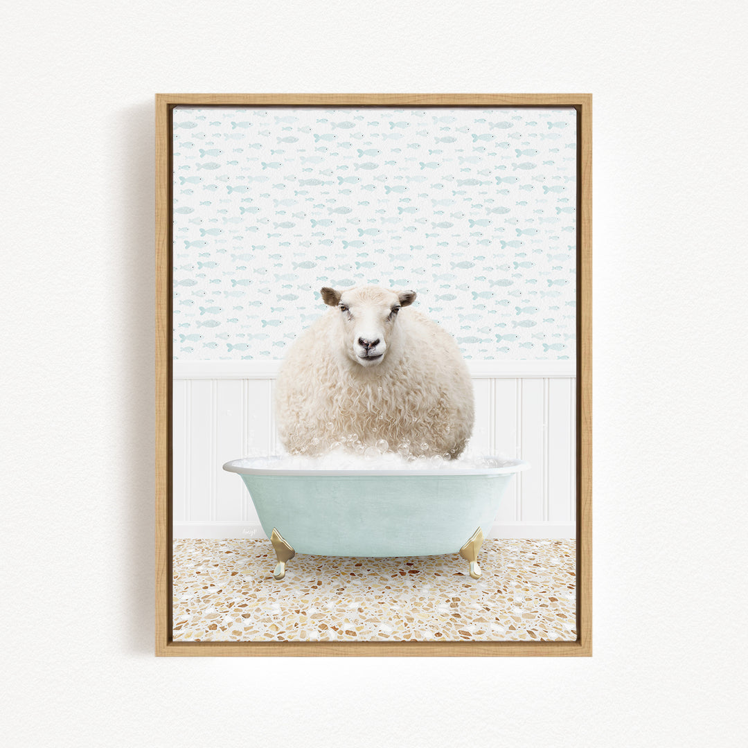 A fluffy white sheep sits in a light blue bathtub filled with bubbles, surrounded by a patterned tile floor and a white wall with a fish-themed wallpaper.