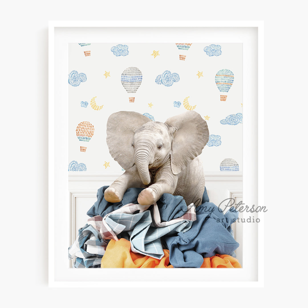 a picture of an elephant sitting on a pile of clothes