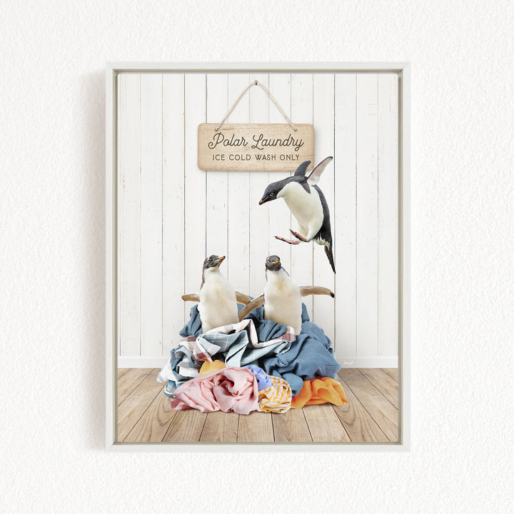 A framed image depicting three penguins on a pile of clothes, with a sign that reads "Polar Laundry Ice Cold Wash Only".