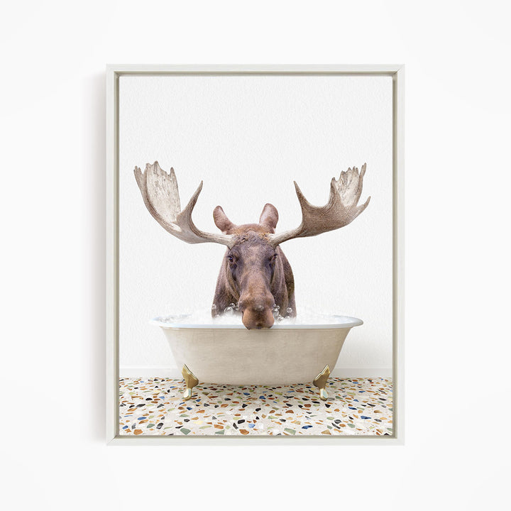 A moose with large antlers is sitting in a bathtub filled with water, creating a whimsical and humorous scene.