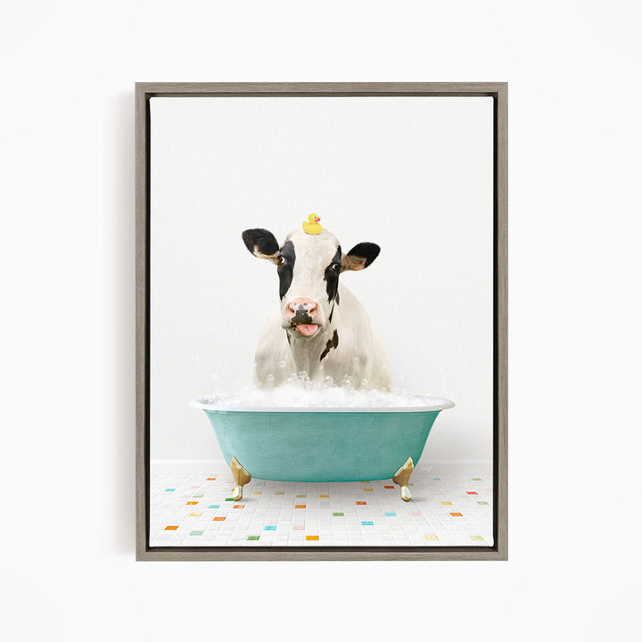 A cow is sitting in a blue bathtub filled with bubbles, with a rubber duck perched on its head.