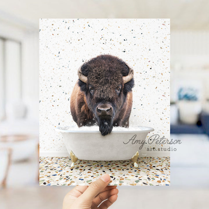 a hand holding up a card with a picture of a bison in a bathtub