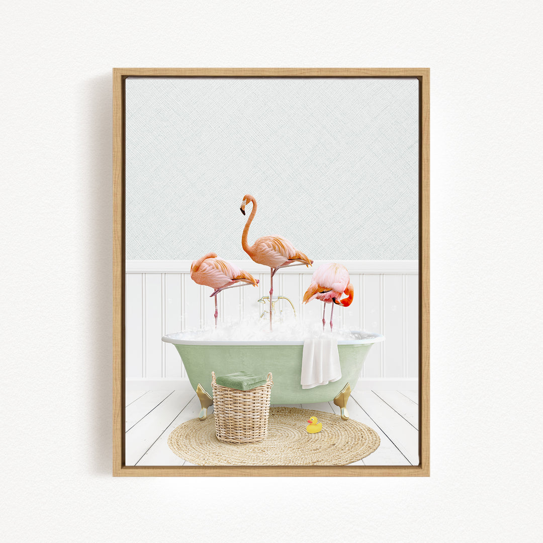 A framed image depicting three flamingos standing in a green bathtub filled with bubbles, with a basket of rubber ducks nearby.