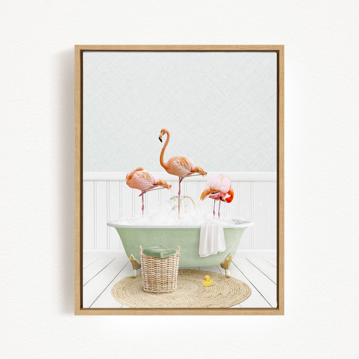 A framed image depicting three flamingos standing in a green bathtub filled with bubbles, with a basket of rubber ducks nearby.