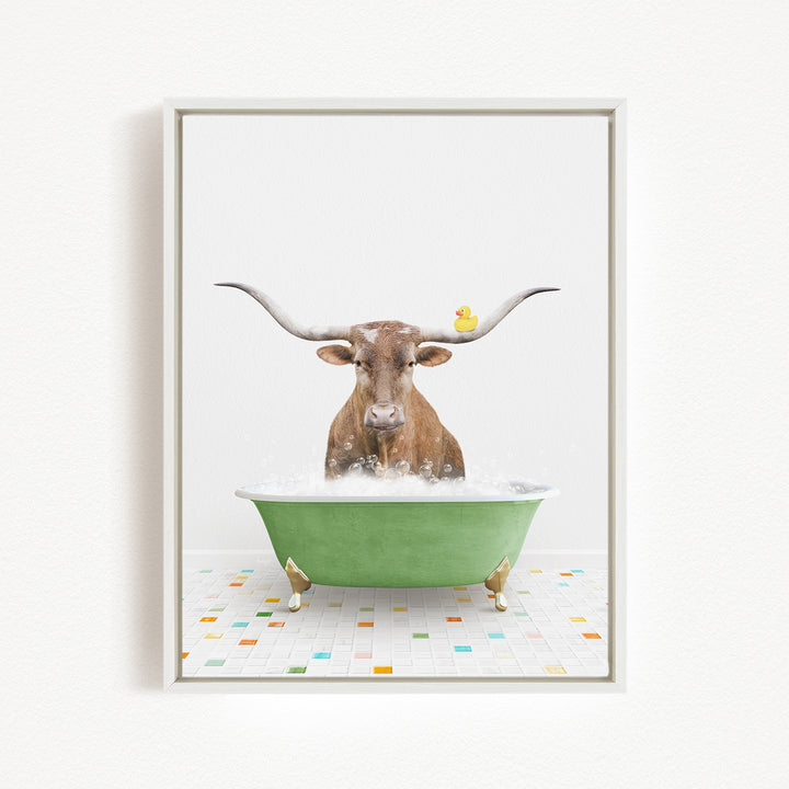 A brown cow with long horns is sitting in a green bathtub filled with bubbles, with a rubber duck floating on the water.