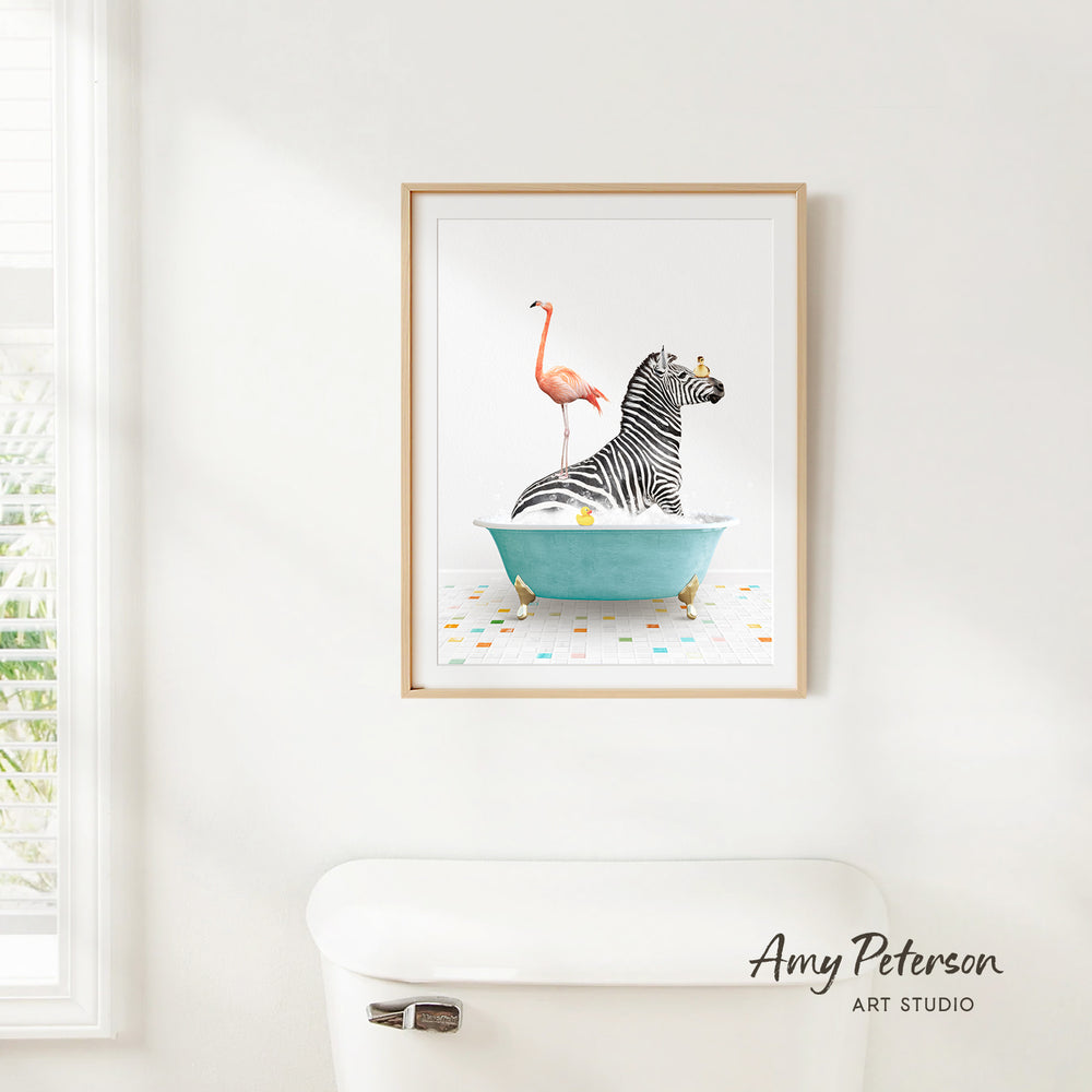 A framed print of a zebra sitting in a bathtub with a pink flamingo on its back, surrounded by colorful tiles.