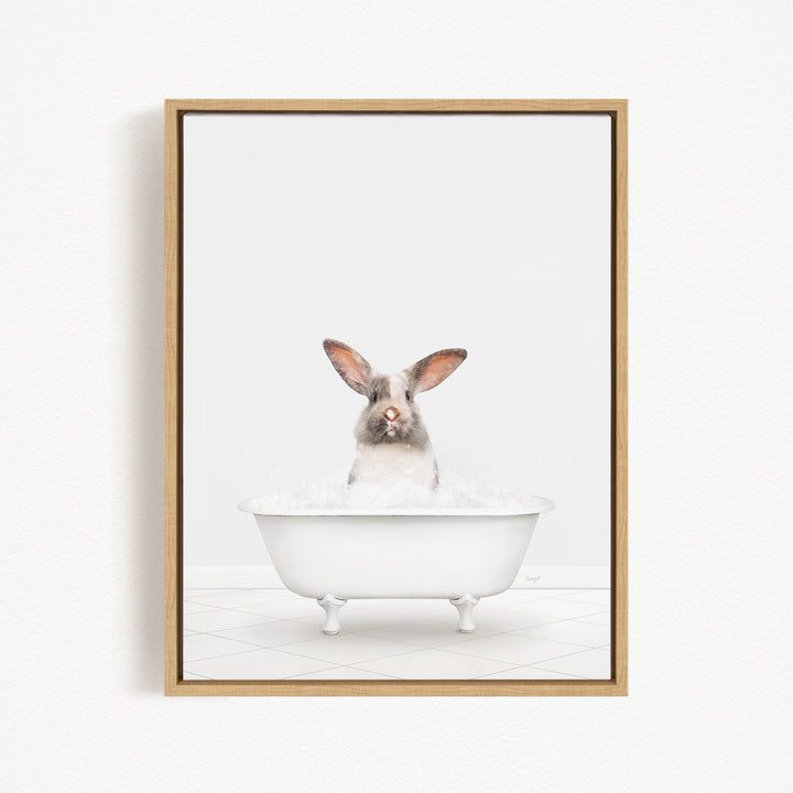 A white rabbit sitting in a white bathtub filled with water, looking directly at the camera.
