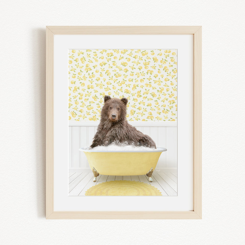 A brown bear sitting in a yellow bathtub filled with bubbles, surrounded by a yellow floral wallpaper.