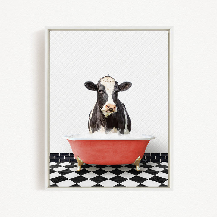 A black and white cow is sitting in a red bathtub filled with water, creating a whimsical and humorous scene.