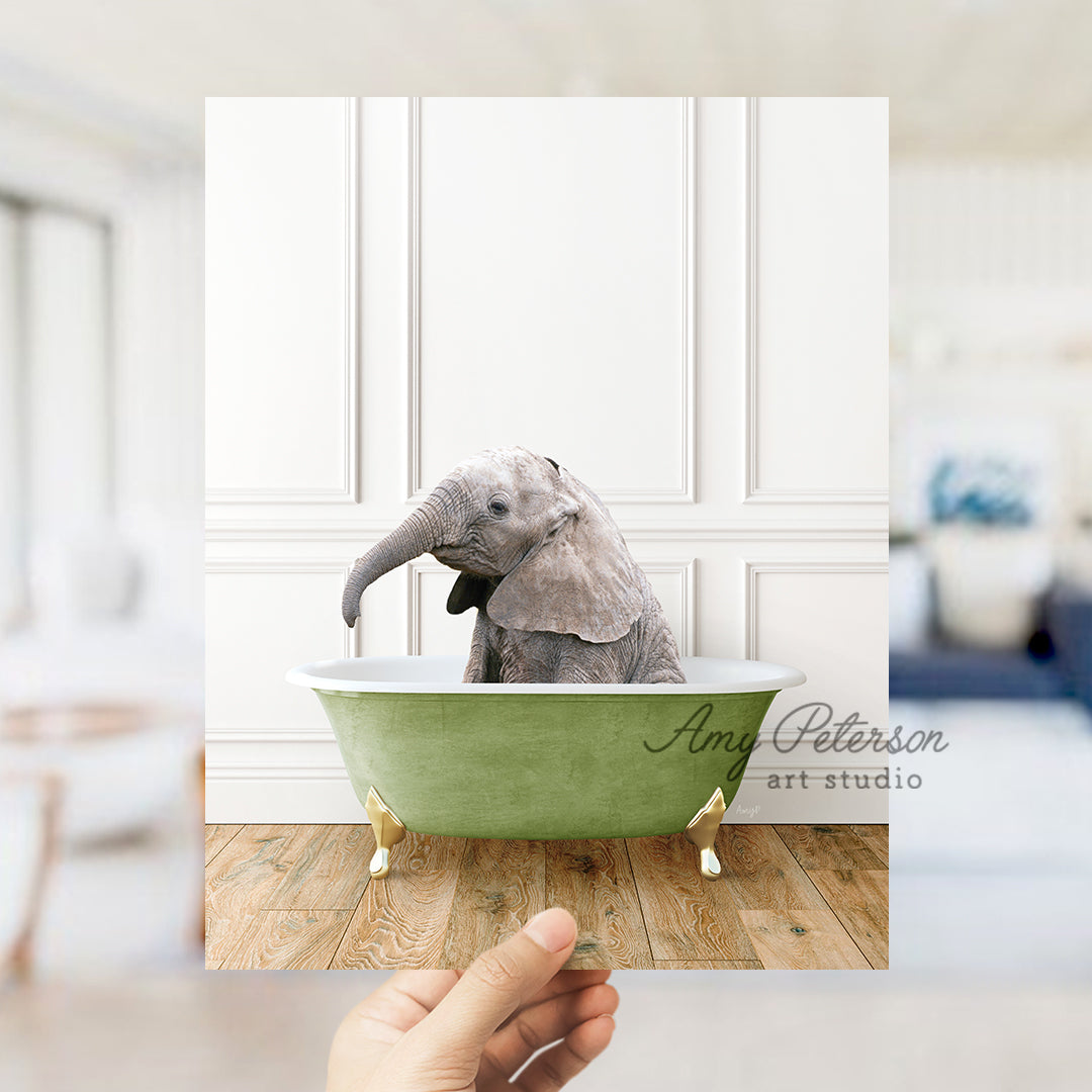 a hand holding a photo of an elephant in a bathtub