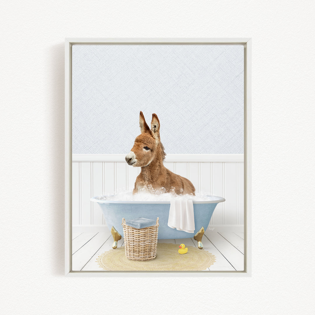 A donkey is sitting in a bathtub filled with water, surrounded by a yellow rubber duck and a wicker basket.