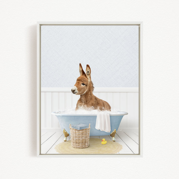 A donkey is sitting in a bathtub filled with water, surrounded by a yellow rubber duck and a wicker basket.