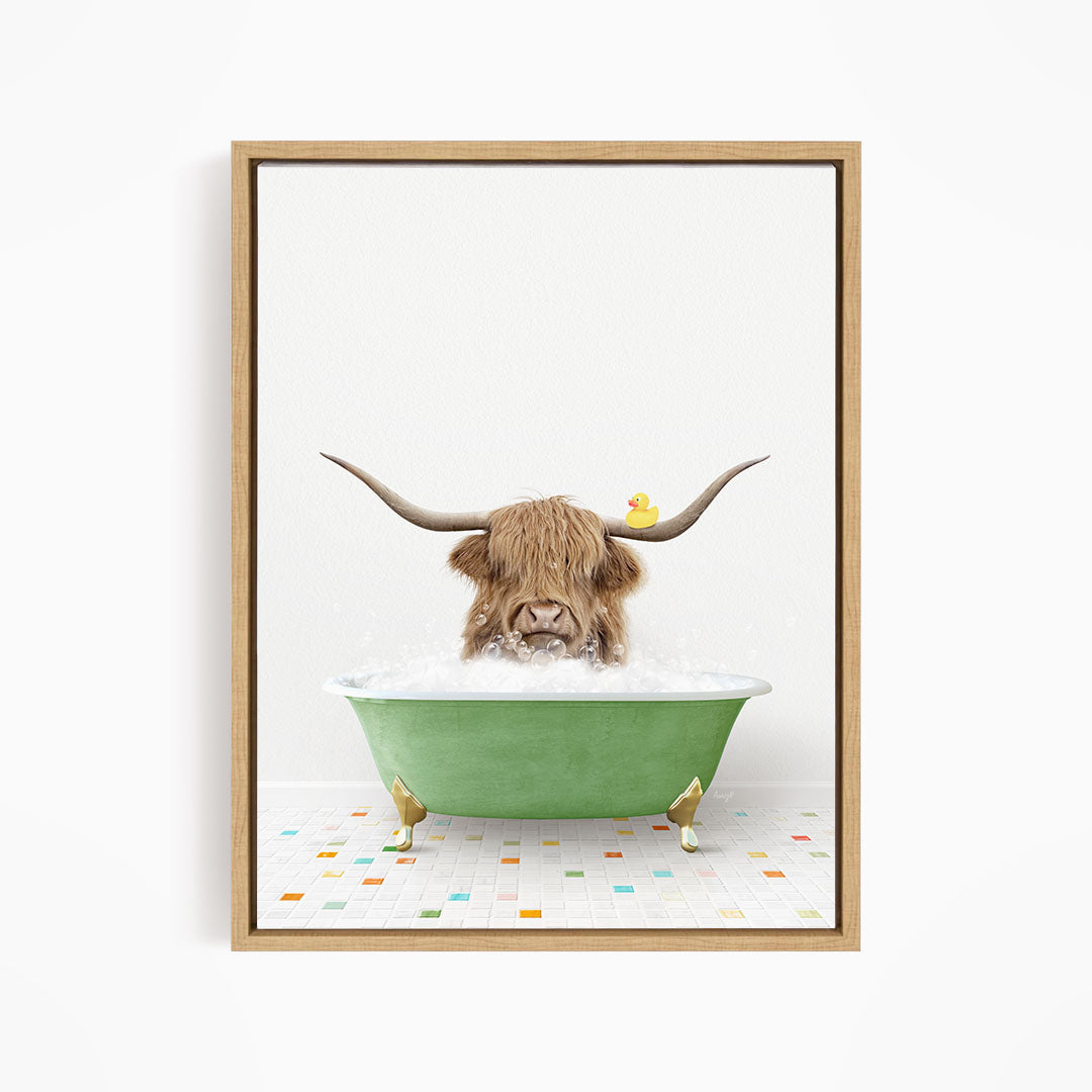 A brown cow with long horns is sitting in a green bathtub filled with bubbles, with a rubber duck floating on the water.
