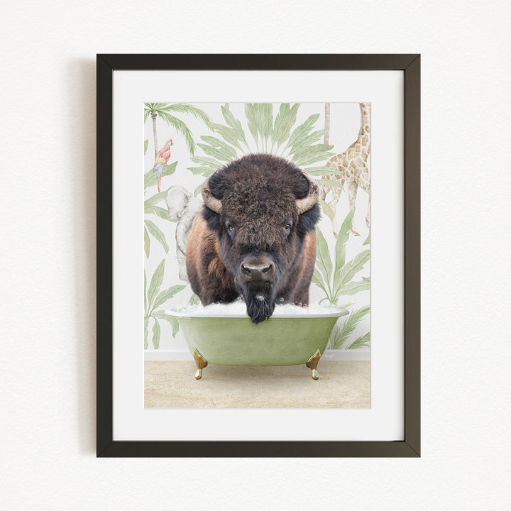 A framed image depicting a bison sitting in a green bathtub, surrounded by a tropical wallpaper with a giraffe and other animals.