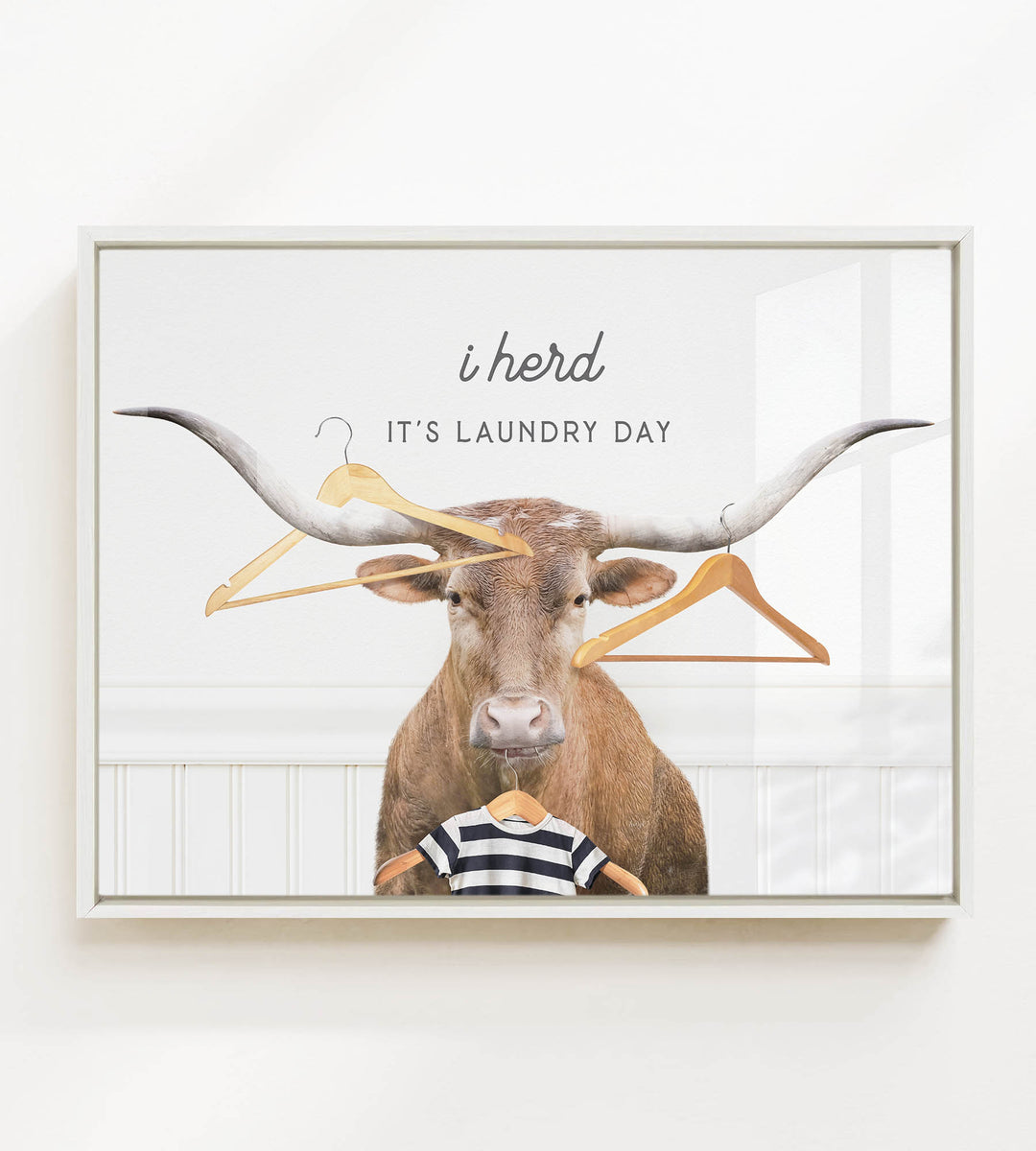 A bull with large horns is surrounded by clothes hangers, with the text "i herd, it's laundry day" displayed above the bull.
