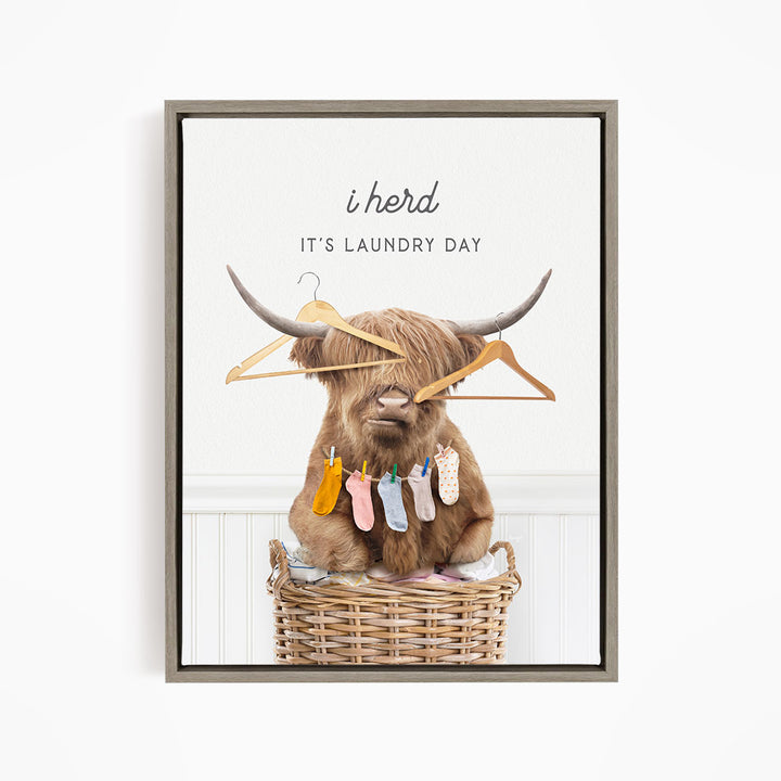 A brown cow with horns sits in a wicker basket, holding clothes on its horns and surrounded by clothes hanging on a clothesline.