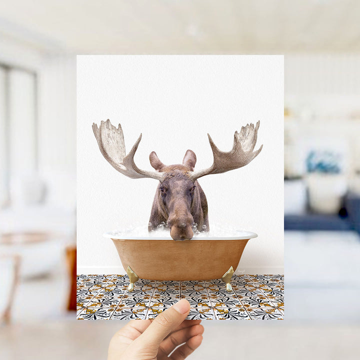 A moose with large antlers is sitting in a bathtub filled with water, creating a whimsical and humorous scene.