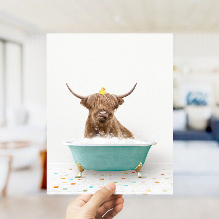 A brown cow with horns is sitting in a blue bathtub filled with bubbles, with a yellow rubber duck perched on its head.