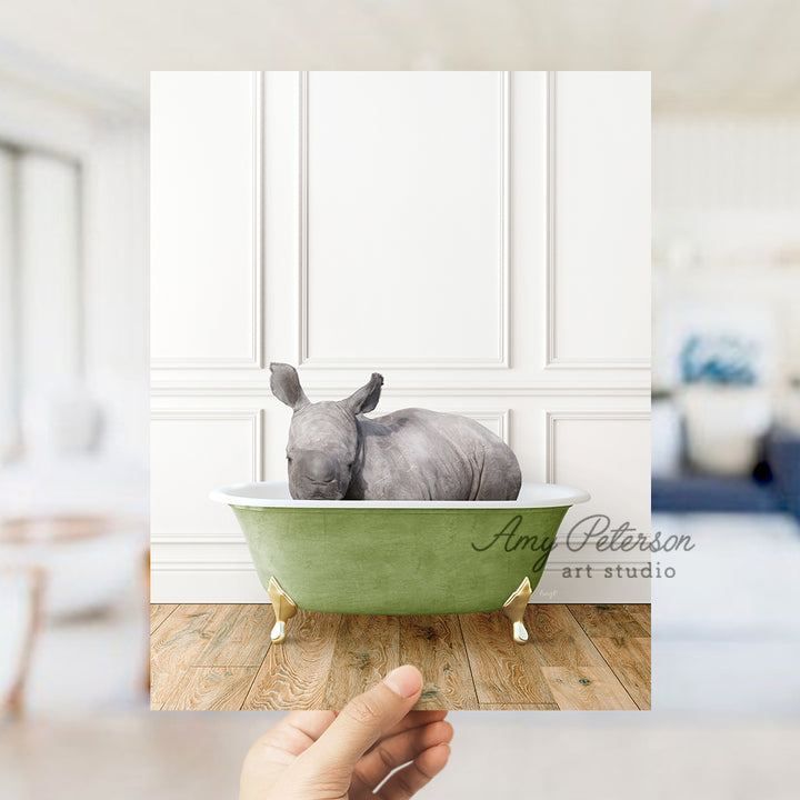 a hand holding a photo of a rhino in a bathtub