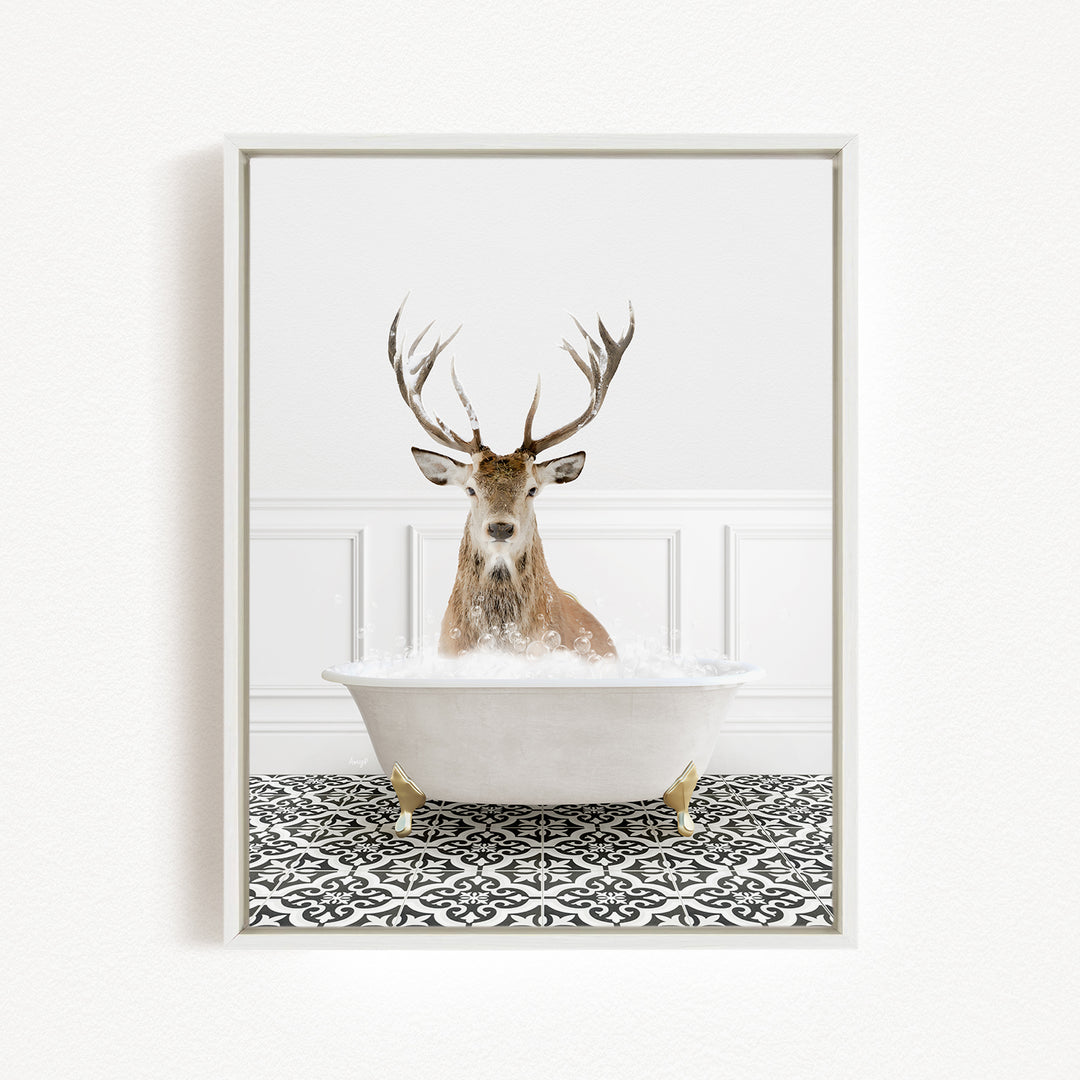 A deer with large antlers is sitting in a white bathtub filled with water, creating a whimsical and unexpected scene.