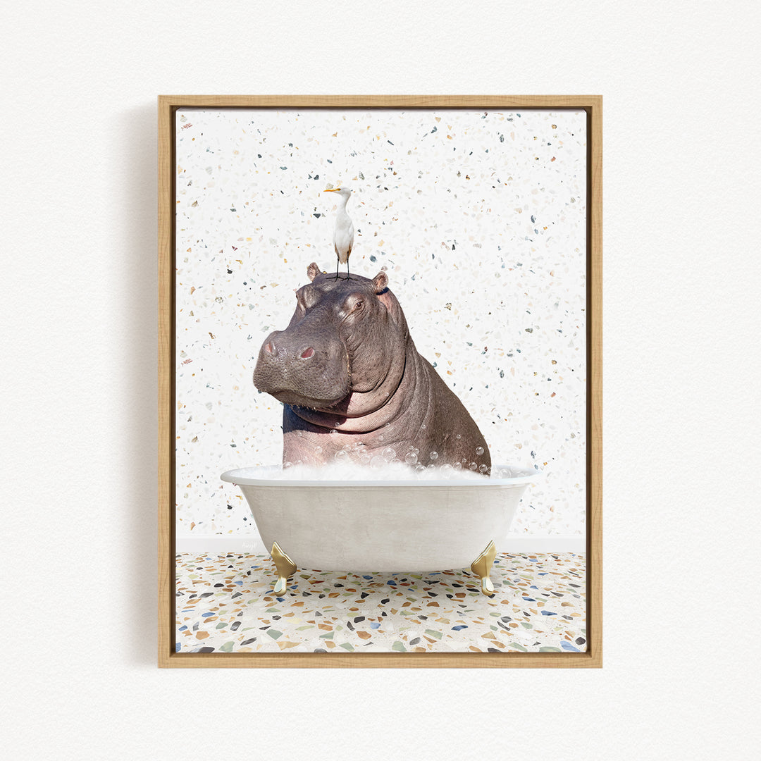 A framed image depicting a hippopotamus sitting in a bathtub, with a bird perched on its head.