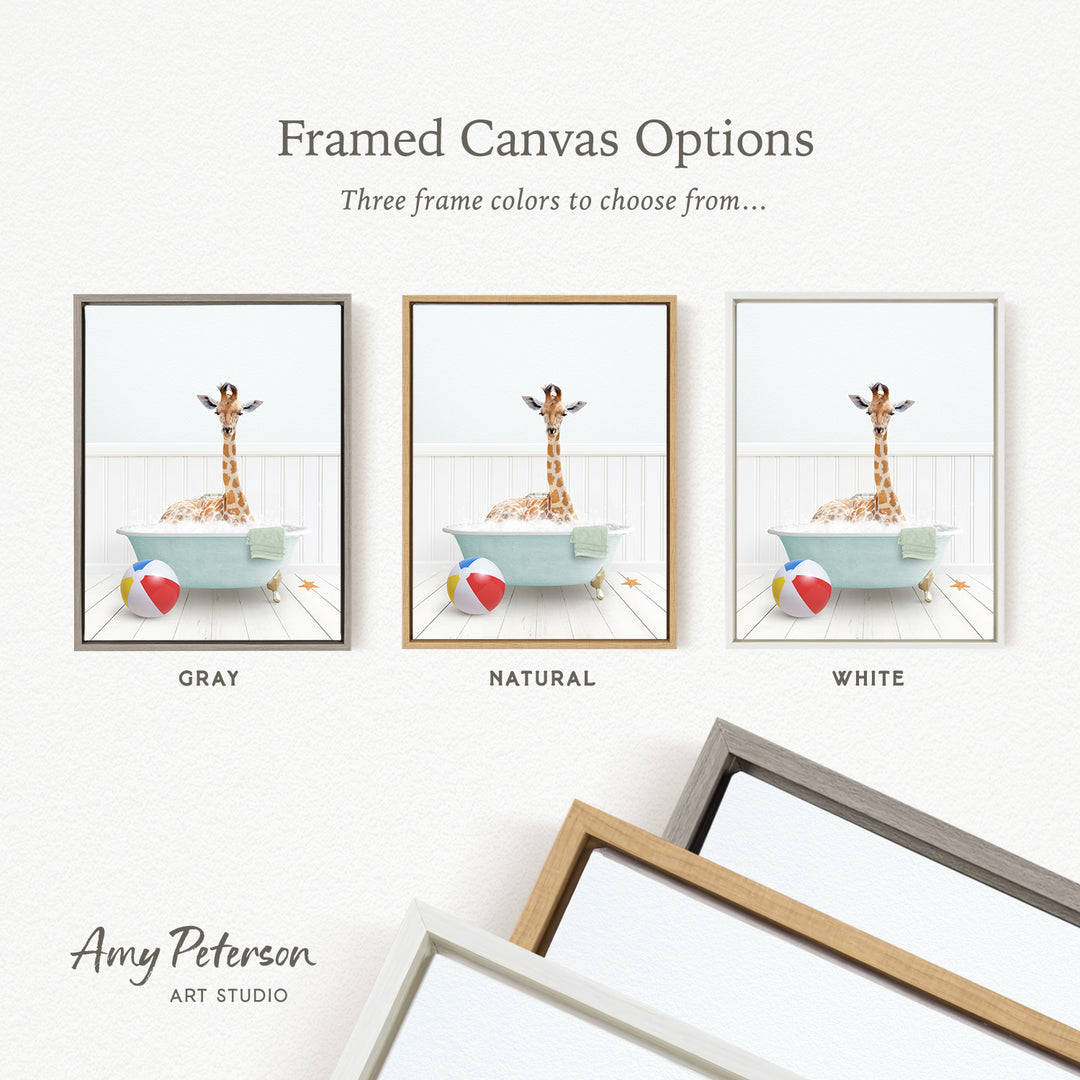 The image is a framed canvas option showcasing three different frame colors: gray, natural, and white. The canvas features a giraffe sitting in a bathtub with a beach ball and starfish nearby.