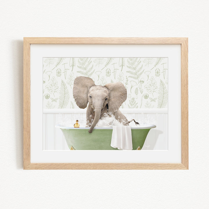 A framed image depicting an elephant sitting in a green bathtub filled with water, surrounded by a patterned wall.