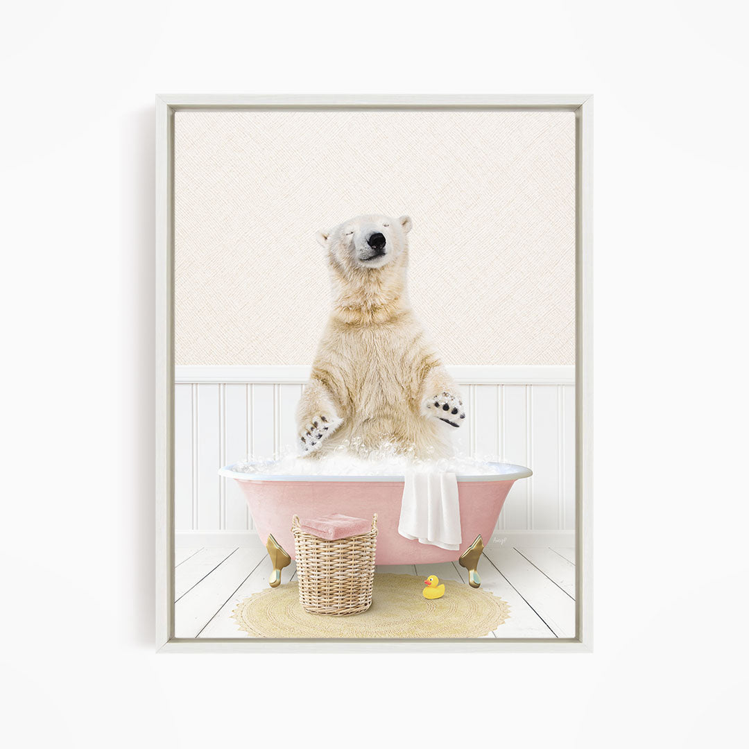 A polar bear sitting in a pink bathtub filled with bubbles, surrounded by a yellow rubber duck and a wicker basket.