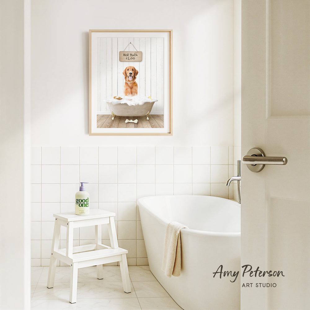 A framed image of a dog sitting in a bathtub, with a sign above it that says "Hot bath $1.00". The image is set in a bathroom with a white bathtub, a stool, and a towel.