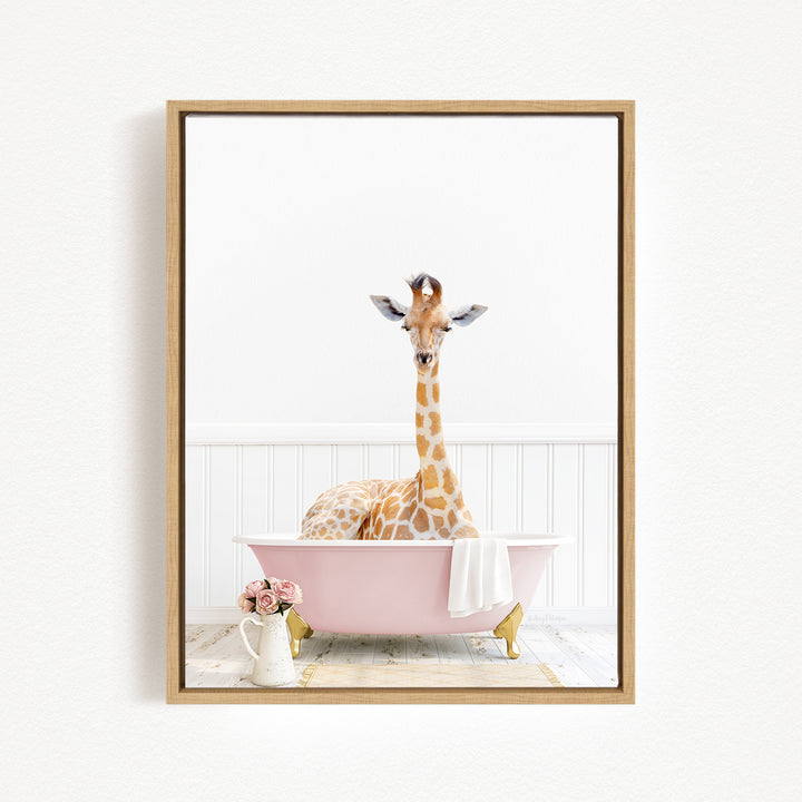 A giraffe sitting in a pink bathtub, surrounded by flowers and a white vase.