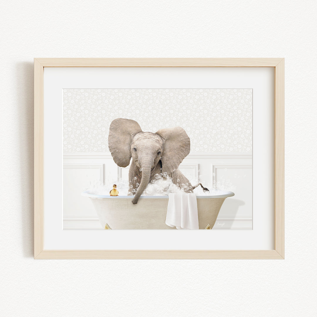 A baby elephant sitting in a bathtub filled with water, surrounded by bubbles and a toy.