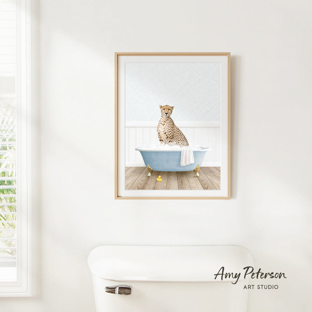 A cheetah sitting in a bathtub filled with water, as depicted in a framed artwork hanging on a white wall.