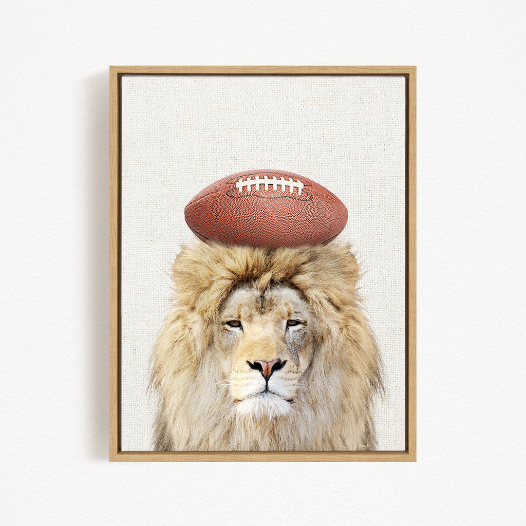A framed image of a lion with a football on its head.