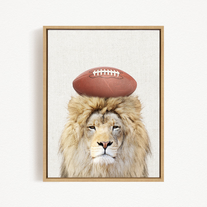 A framed image of a lion with a football on its head.