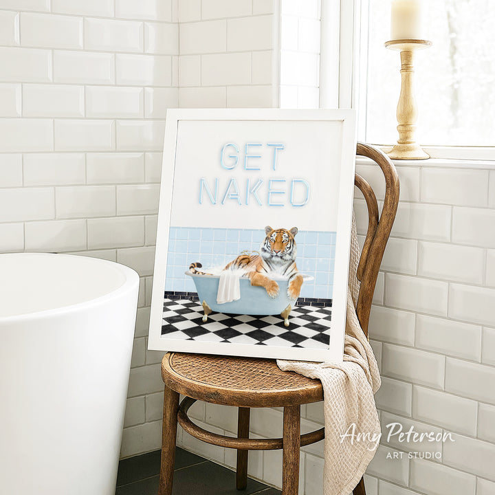 A framed print of a tiger sitting in a bathtub, with the text "GET NAKED" displayed on the frame.