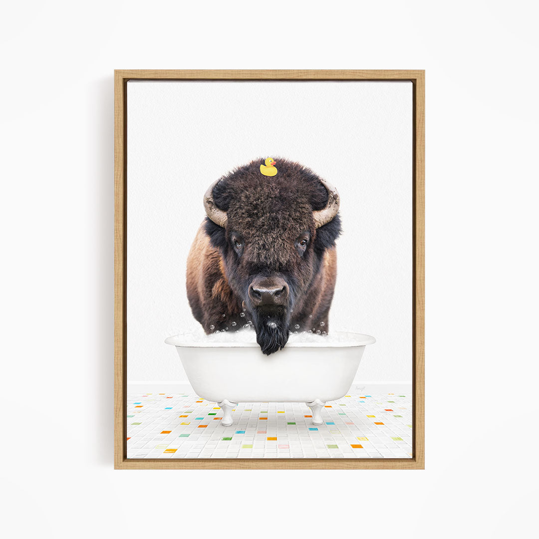 A buffalo with a yellow rubber duck sitting in a white bathtub.